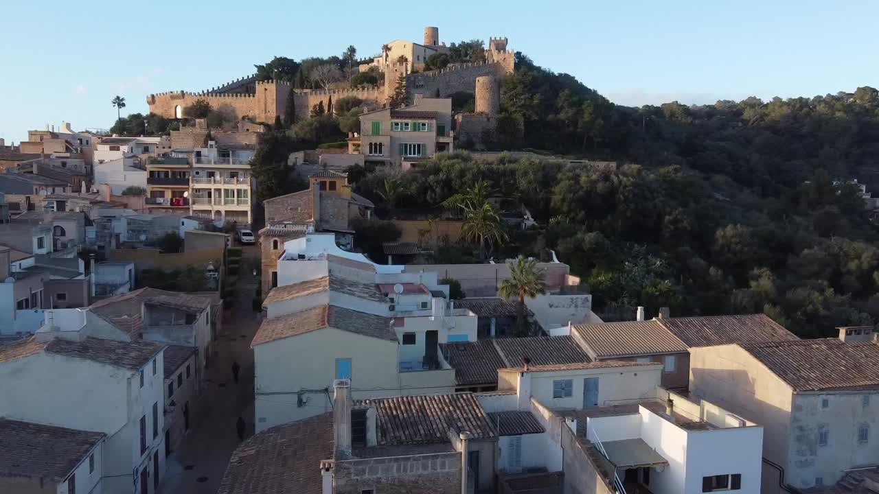 Volando verso il Castello di Capdepera, sorvolando la città al tramonto. Maiorca, Spagna.