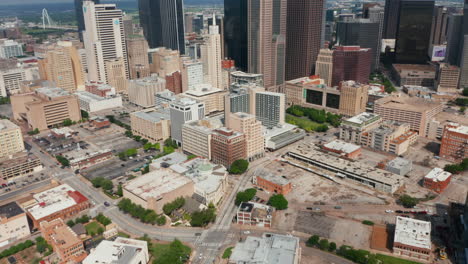 Tilt-up-reveal-of-modern-downtown-skyscrapers.-Forwards-fly-above-streets-of-city.-Dallas,-Texas,-US