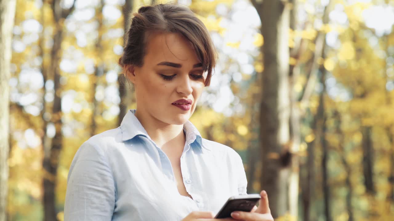 Donna con telefono cellulare. Donna che trascorre del tempo con il telefono cellulare al parco