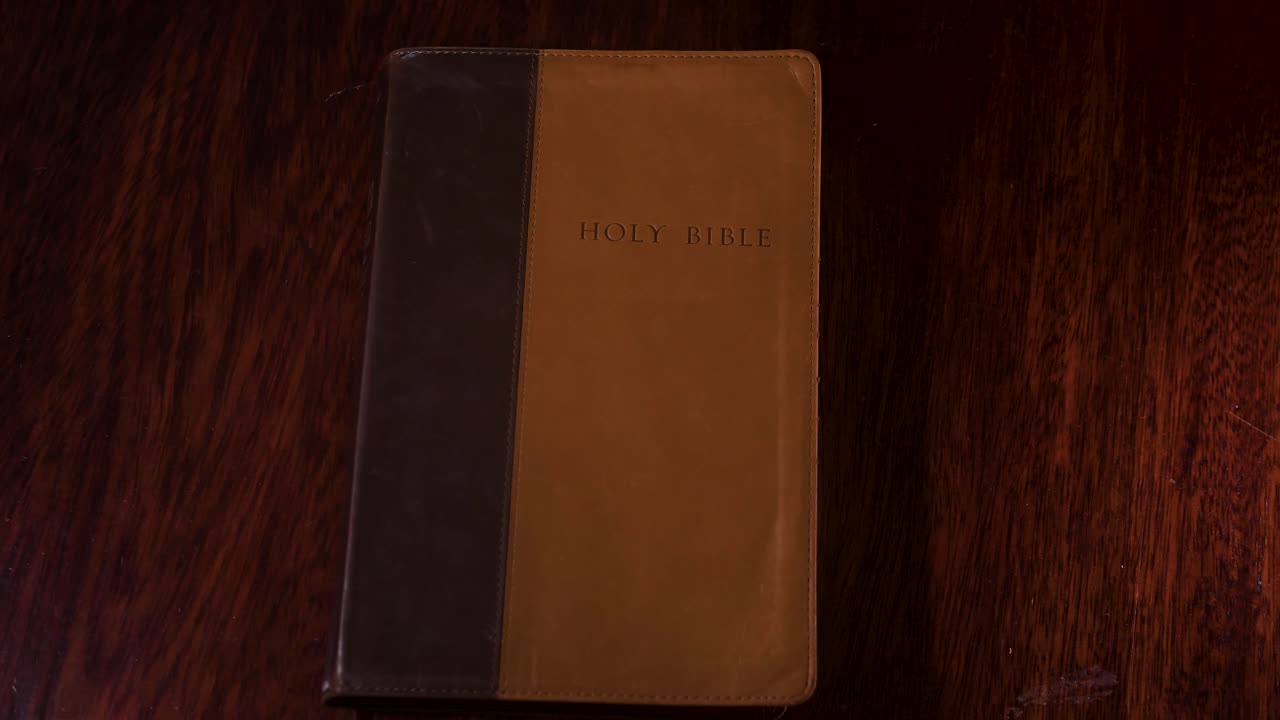 Ripresa dall'alto di una bibbia di pelle marrone posizionata su un tavolo.