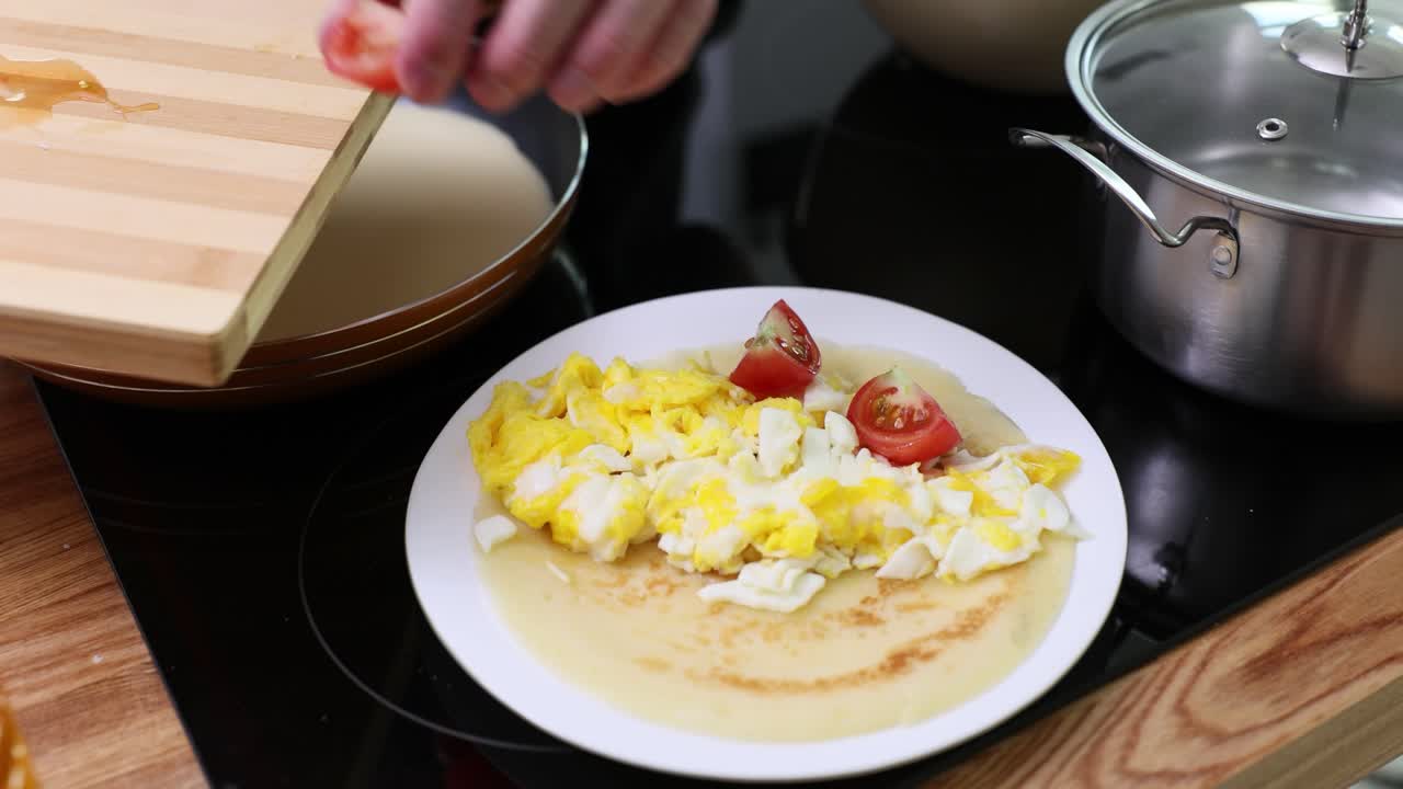 Preparing a Pancake with Eggs and Tomatoes
