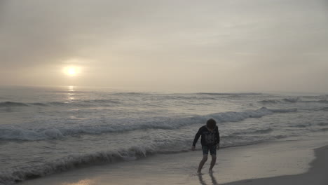 children playing on beach at sunset or sunrise