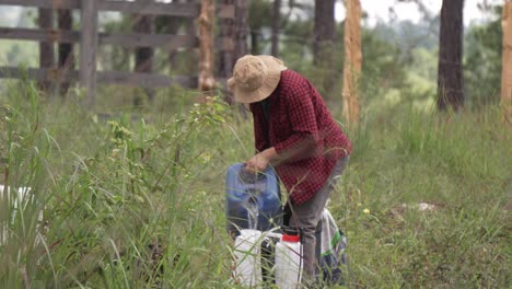 Forest-ranger-man-in-the-forest-filling-a-backpack-sprayer-with-water-to-water-the-new-trees