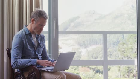 Man-using-laptop-in-balcony-4k