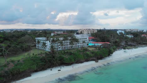 playa de mombasa durante una puesta de sol nublada, con resorts al fondo