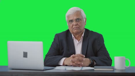 un hombre de negocios indio de alto nivel mirando la pantalla verde de la cámara.