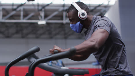 Hombre-Afroamericano-Con-Mascarilla-Haciendo-Ejercicio-En-El-Gimnasio