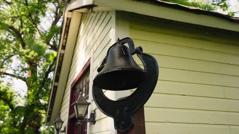 orbiting shot of a bell on the exterior of an old school house