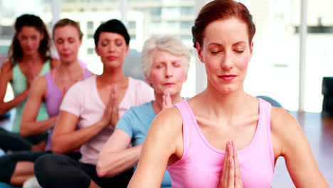 group of peaceful women in fitness studio doing yoga