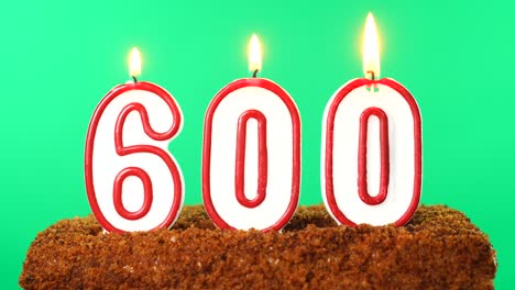 cake with the number 600 lighted candle. chroma key. green screen. isolated