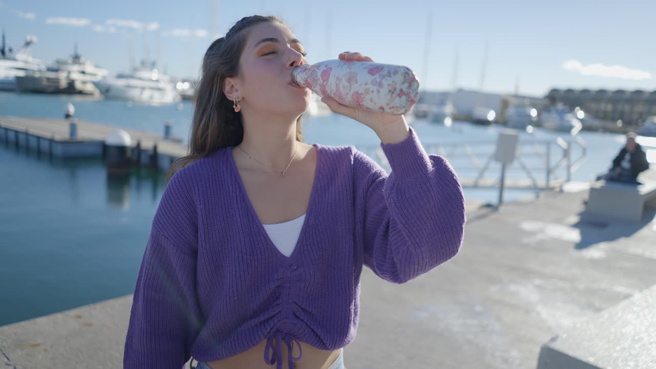 Young Woman Drinking Water at the Harbor