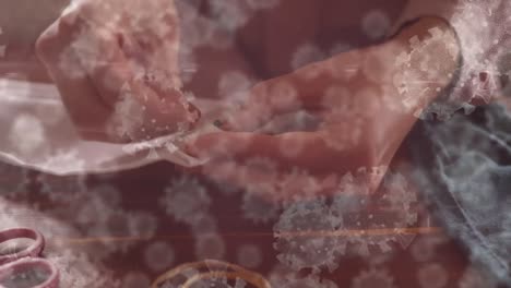 animación de las células de covid-19 sobre una persona cosiendo una máscara facial