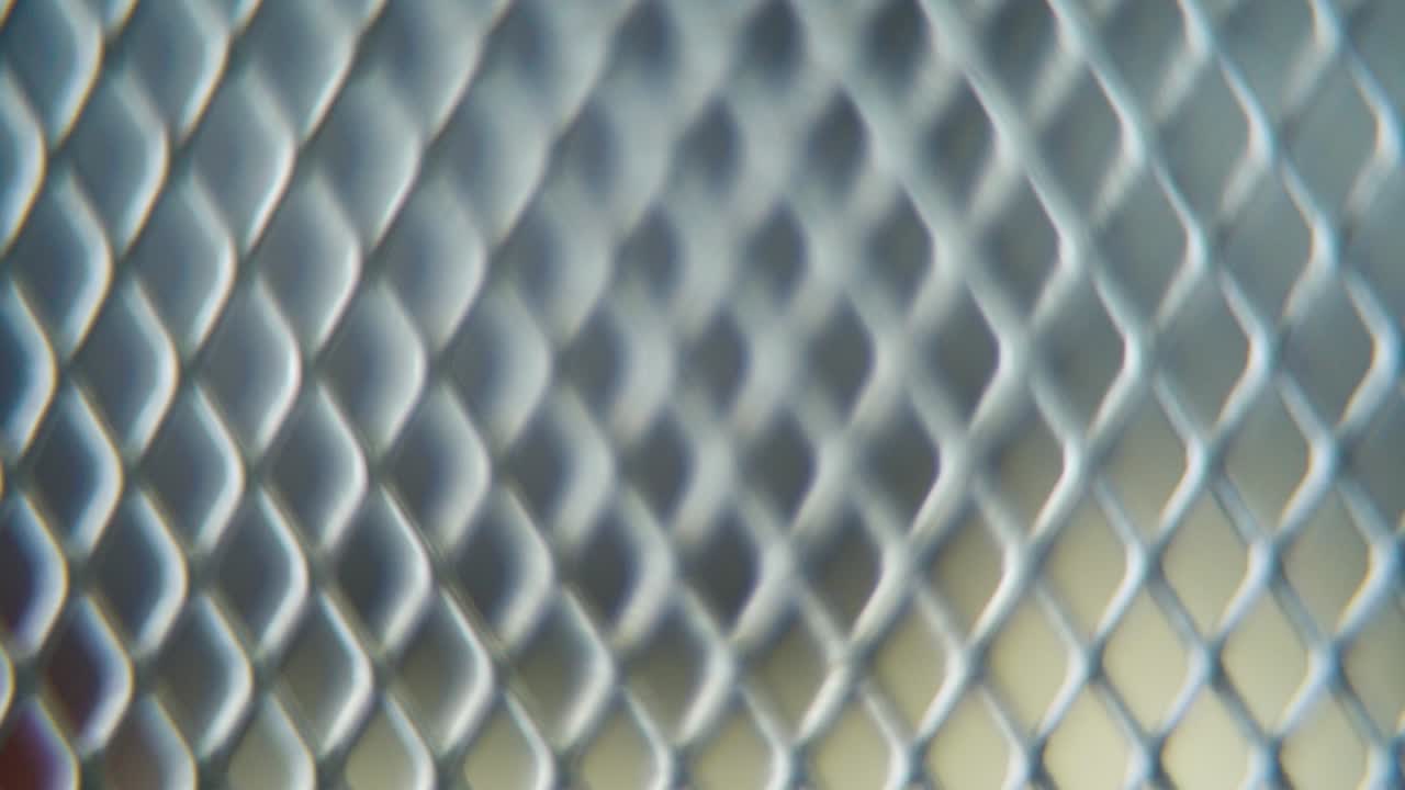 una toma macro hiper de una cuadrícula metálica, patrón de acero, textura industrial de hierro, material de aluminio, cámara súper lenta, full hd 120 fps, movimiento de zoom suave, profundidad de campo borrosa