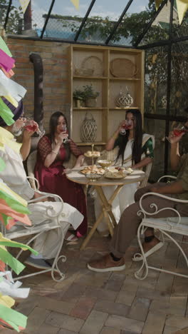four people toasting at a festive outdoor gathering