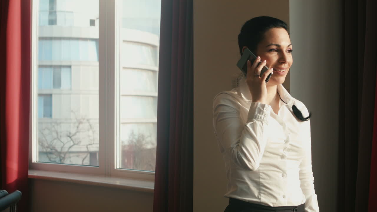Businesswoman on a Phone Call by the Window