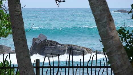 olas del océano rompiendo en enormes rocas de la playa tropical en sri lanka - tiro estático