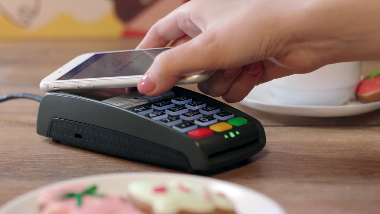 Mobile NFC payment for order in cafe. customer paying through mobile phone