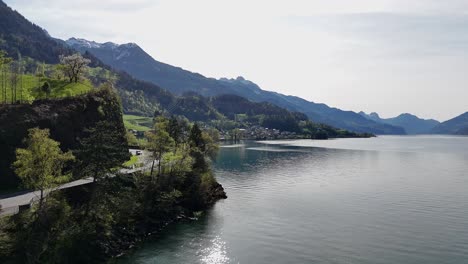 Cars-on-road-along-swiss-lake-in-idyllic-landscape-and-green-mountains