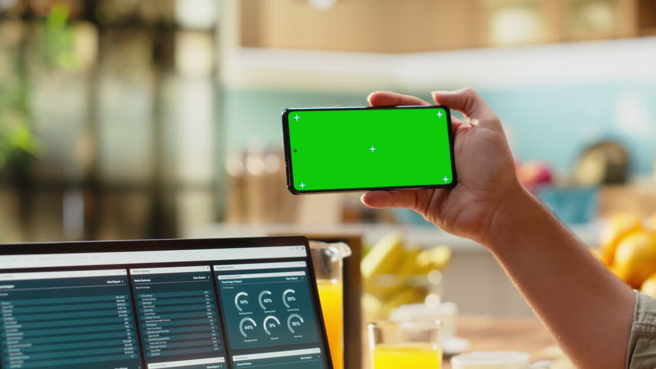 Schermo verde sul telefono, professionista che lavora in remoto, utilizzando il laptop
