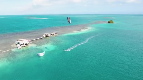 man kiteboard alone on blue water caribbean sea palafito los roques, drone shot