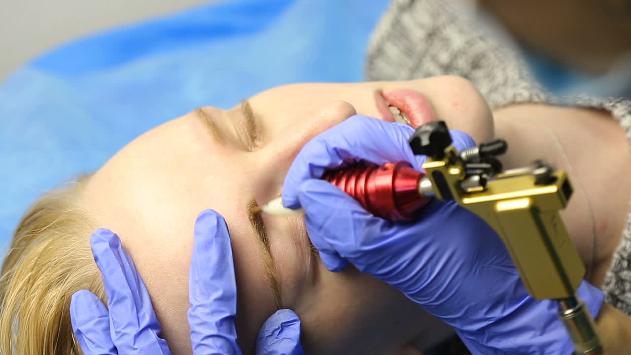 Tattooist making permanent make-up. Close up of specialist doing eyebrow tattooing for female