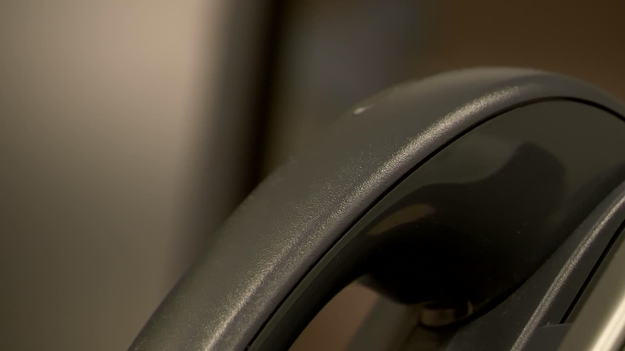 슬로우 모션으로 사무실 책상 칸막이 전화에 전화를 끊는 손의 측면에서 닫습니다