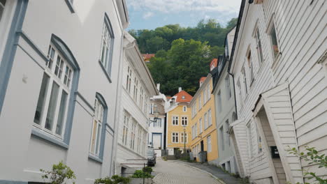 eine schmale straße mit schönen alten holzhäusern in bergen norwegen steadicam-aufnahme