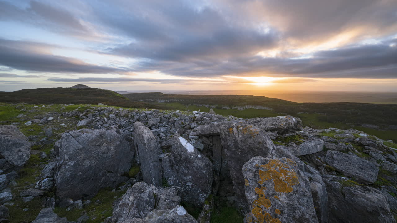 timelapse de movimiento panorámico del paisaje de la naturaleza rural con ruinas de la tumba del pasaje prehistórico en primer plano durante la espectacular puesta de sol vista desde carrowkeel en el condado de sligo en irlanda