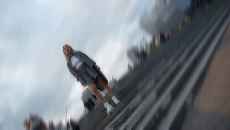 casual woman standing city square near crowded street urban background.