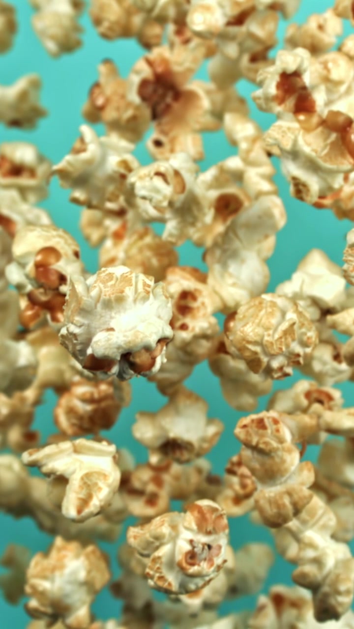 Slow Motion Popcorn Falling on a Blue Background