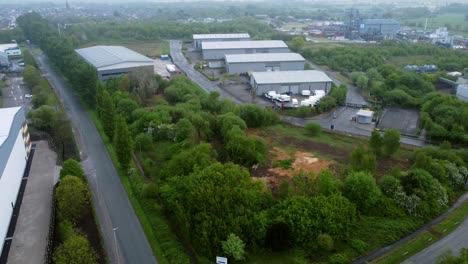 industrial processing warehouse depot aerial view across green space ecological park land