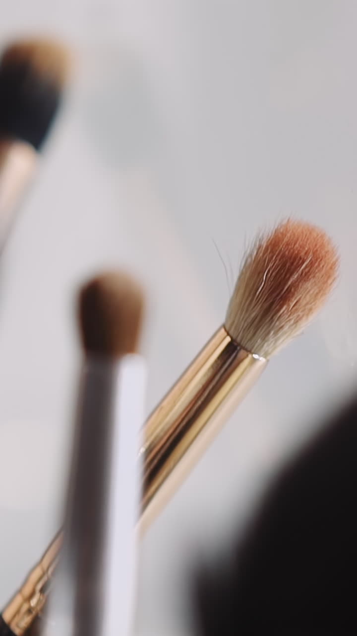 Different cosmetic brushes on workplace of professional makeup artist in beauty salon extreme closeup. Accessories to apply powder blush eyeshadows