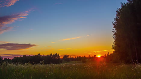 Zeitraffer-Der-Untergehenden-Sonne-über-Einem-Rapsfeld-Mit-Rollenden-Wolken,-Die-Sich-In-Rosa-Violette-Farbe-Verwandeln