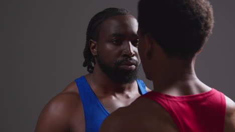 close up of male boxer and opponent standing face to face before boxing match staring at each other 7