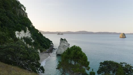 Aerial-Reveal-of-Te-Hoho-Rock-at-New-Zealand's-famous-Cathedral-Cove-during-Sunset