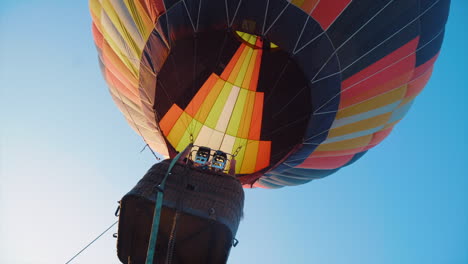 un globo de aire caliente despegando de un campo llano, contra el telón de fondo de un cielo despejado y nevado