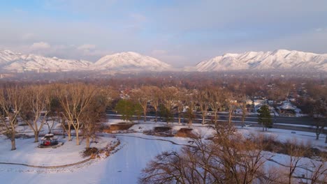 flock of seagulls soar in sky above liberty park covered in snow with epic utah canyons in background during winter