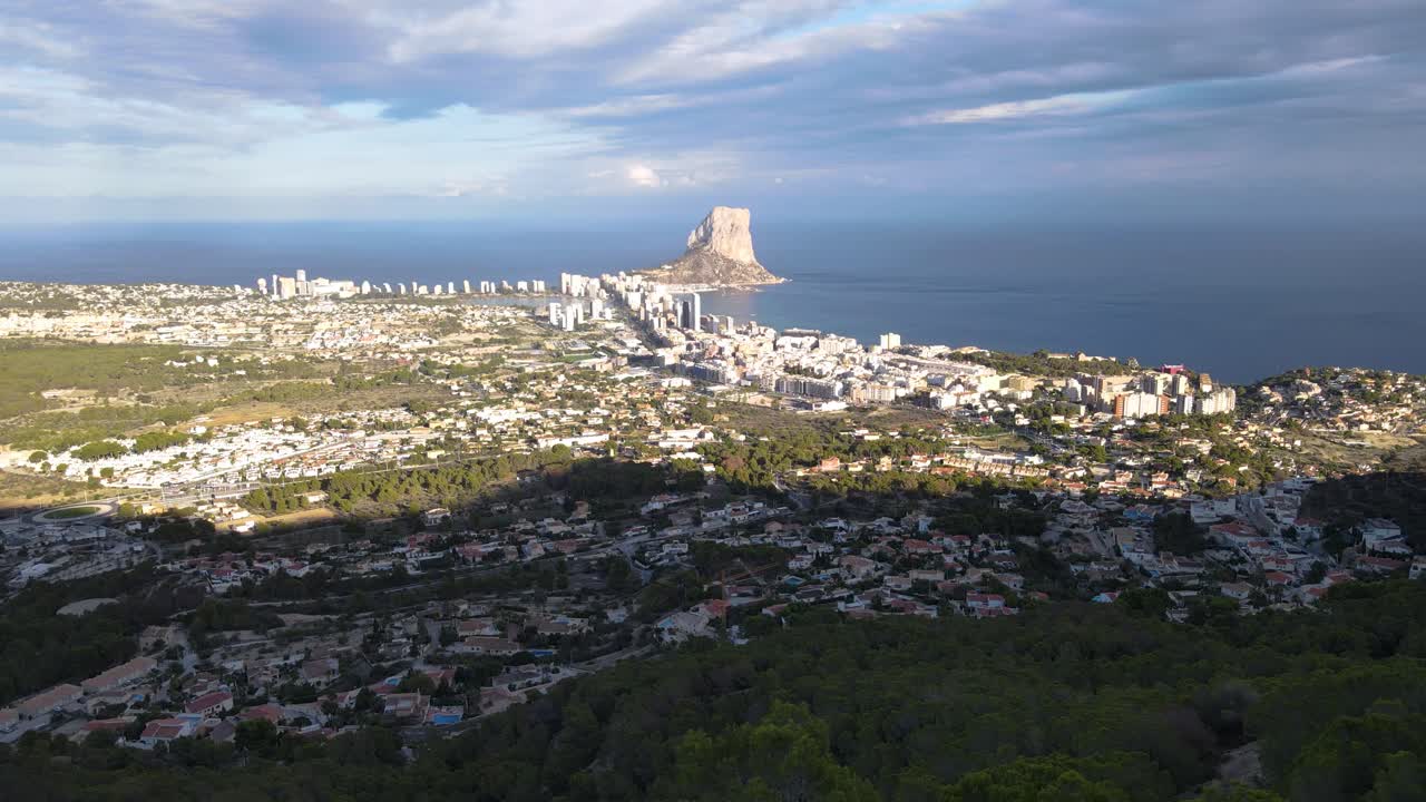 Calpe's coastline with penyon d'ifach rock formation and surrounding town, aerial view
