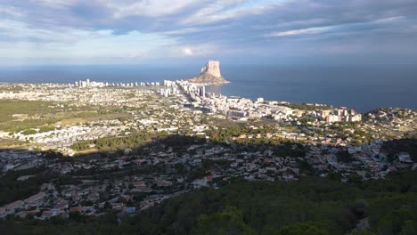 calpe's coastline with penyon d'ifach rock formation and surrounding town, aerial view