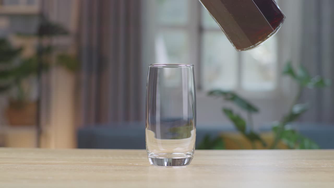 테이블 위 에 있는 유리잔 에 신선 한 콜라 가 부어지고 있다
