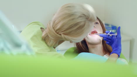 dentist doing anesthesia of young woman. female dentist using mouth mirror