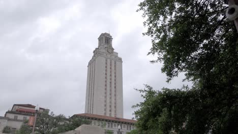 Main-building-at-the-University-of-Texas-in-Austin,-Texas-with-gimbal-video-walking-forward-past-trees-in-slow-motion