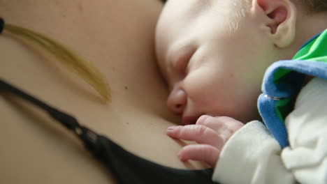 close up - beautiful newborn baby snuggles close to mother