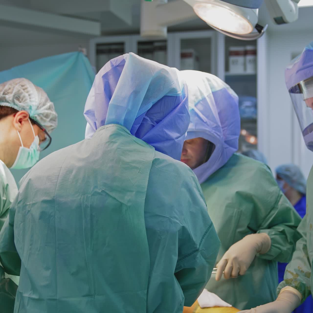 Operating room with surgery in progress. Medical team performing surgical operation in bright modern operating room