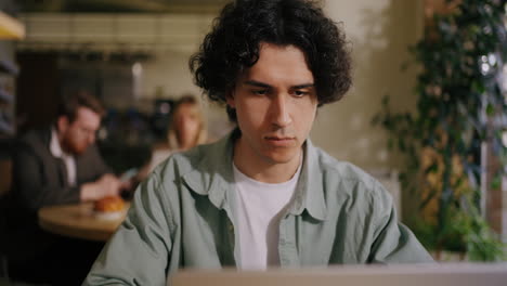 man working on laptop in a coffee shop