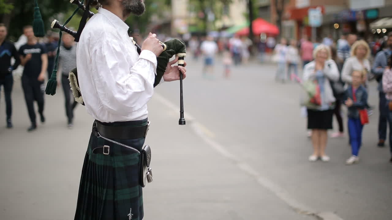 Bagpiper Playing Music With Bagpipe. VINNISA, UKRAINE - MAY 2017: Bagpiper, street musician performer, playing on the street