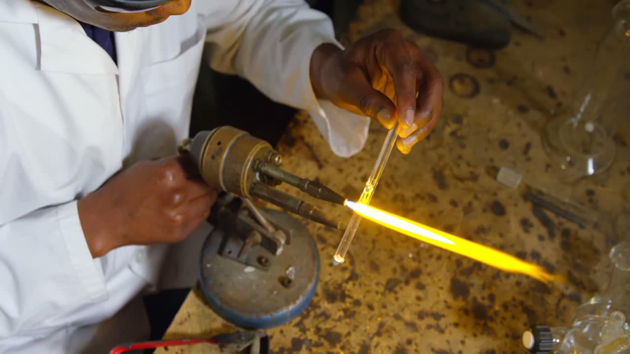 High angle view of male worker blowing glass in glass factory 4k