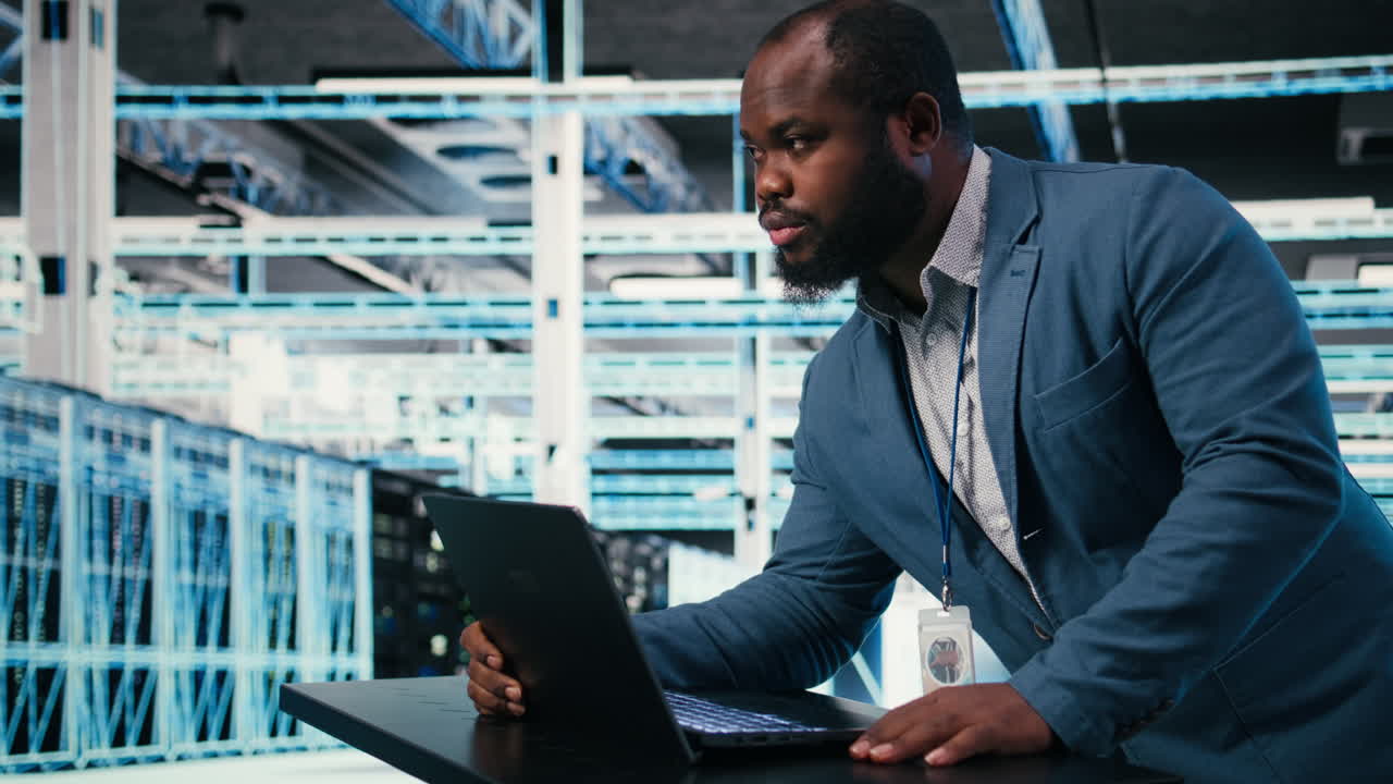 African American IT Engineer Working on Laptop in Data Center