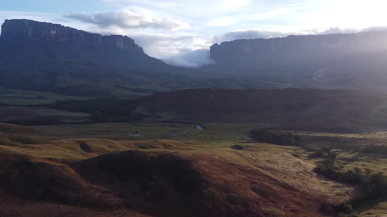 Aerial ascent revealing Tek river camp and Kukenan and Roraima tepuis in the background