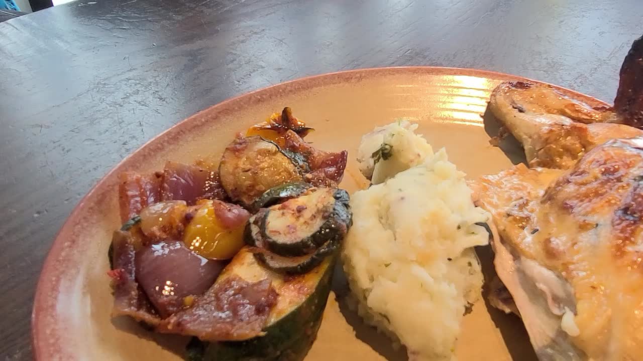 2-2 돌리 롤 클로즈업 세미 서클 카메라 팬 위에 구이 야채를 곁들인 구운 바비큐 치킨 양념 마늘 으깬 감자가 나무 빈티지 테이블의 세라믹 접시에 제공됩니다.